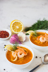 Lentil soup with seafood. Red soup with shrimps and squid