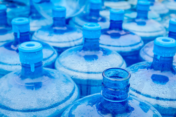 Big blue drinking water barrels, bottles, gallon, gets wet in the rain