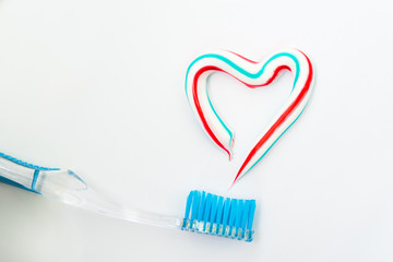 the heart symbol is made from a three-color toothpaste and is located above the toothbrush