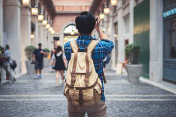 Young Asian traveling backpacker in street city and walking with take a photo and camera, Thailand © aksonsat
