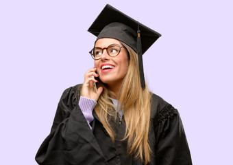 Young woman university graduate student happy talking using a smartphone mobile phone