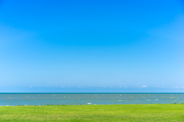 Fototapeta na wymiar Background of green fields, the sea and beautiful blue sky.