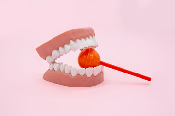 Plastic teeth and dental model with colorful candy, Dental care concept