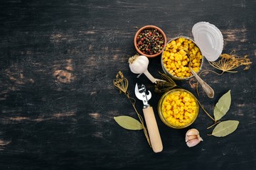 Pickled corn in a jar. Stocks of food. Top view. On a wooden background. Copy space