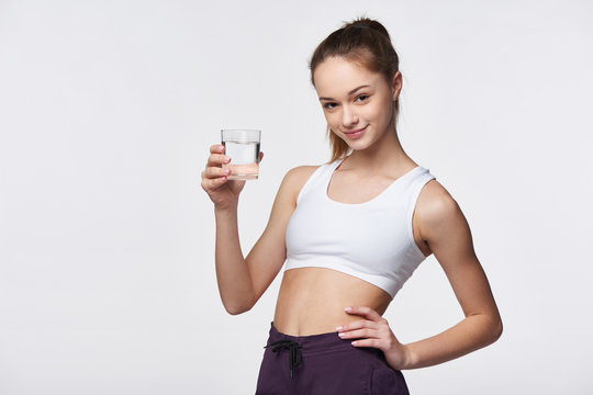 Sporty teen girl with glass of water in hand
