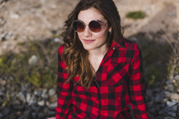 young beautiful woman wearing casual clothes, sitting on the railway and smiling. Outdoors lifestyle. Travel concept.