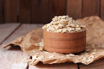 A handful of oatmeal in a wooden bowl on the background of a tree. useful porridge, proper nutrition. minimalism. 