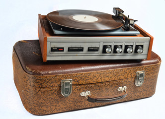 Vinyl player on an old leather suitcase isolated on a white background.
