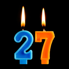 Burning birthday candles in the form of 27 twenty seven for cake isolated on black background. The concept of celebrating a birthday, anniversary, important date, holiday