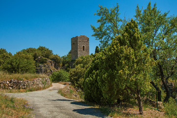 Fototapeta na wymiar Panoramic view of tower on top of hill and path with tree near Chateaudouble, a quiet and tourist village with medieval origin. Located in the Var department, Provence region, southeastern France