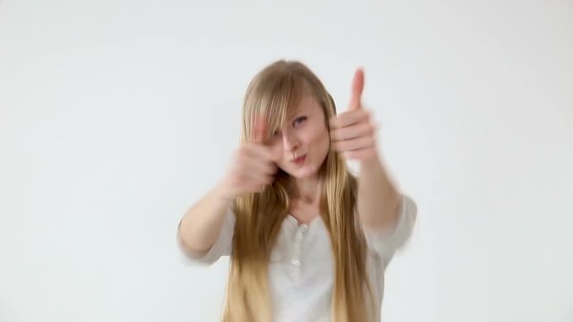 beautiful long-haired girl of European appearance with blond hair showing thumbs up over white abackground