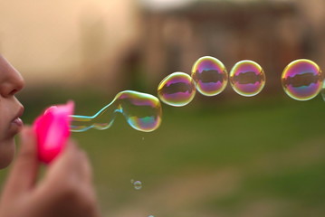 small girl blowing soap bubbles