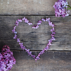 Purple heart Shape from Lilalc Flowers. Spring time. Textured Wooden Board. Flat Lay.