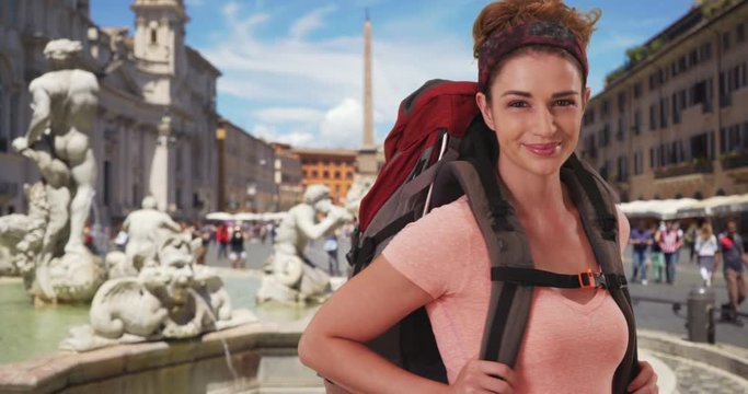 Adventurous woman wearing backpack in Rome posing near Fontana del Moro 