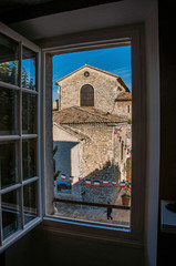 Stone church and people view through window in the village of Vence, a stunning medieval town completely preserved. Located in the Alpes-Maritimes department, Provence region, southeastern France
