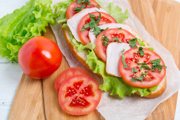 baguette sandwich with ham, tomatoes and lettuce