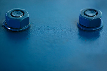 Blue metal rough surface of part with bolts and nuts. Blue painted of auto part. Automotive grunge background image.