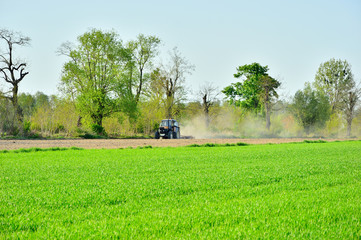 Traktor i maszyna rolnicza podczas pracy na polu.
