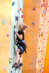 Fototapeta na wymiar little girl climbing up the wall