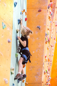 little girl climbing up the wall