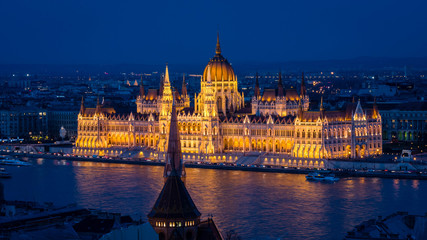Parliament of Budapest after sunset seen from the opposite river bank