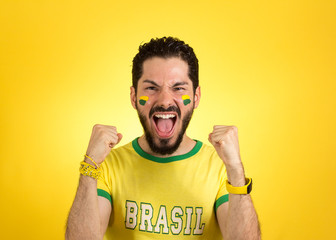 Brazilian supporter of National football team is celebrating, cheering. Male fan.