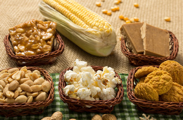 Fototapeta na wymiar Group of food of Festa Junina in wicker baskets, typical brazilian party: Peanut, Cookie, Popcorn, Pe de Moleque, Pacoca, Corn.