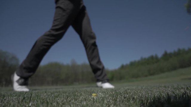 golf club hitting ball on the green artificial grass in slow motion
