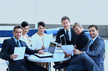 group of business people with documents sitting at a table in the lobby of the Bank.