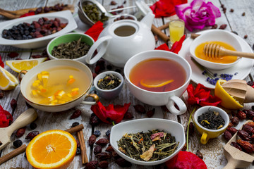 Various leaves of tea and spices on wooden background