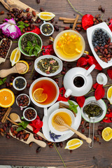 Various leaves of tea and spices on wooden background