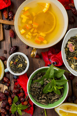 Various leaves of tea and spices on wooden background