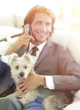 business man talking on the phone and holding his pet