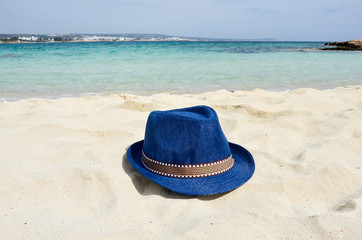 Summer straw hat on a tropical beach near sea.  Holiday relaxing, beach vacation. Copy space