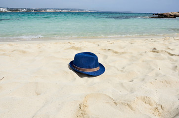 Fototapeta na wymiar Blue color of sea, white sand and straw hat on beach. Holiday relaxing, beach vacation concept. Copy space. Place for text