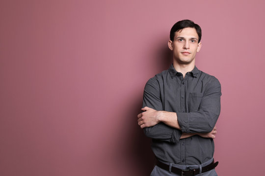 Portrait of confident young man on color background
