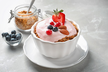 Bowl with yogurt, berries and granola on table