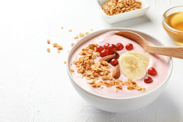 Bowl with delicious yogurt and granola on table
