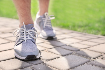 Sporty young man in training shoes outdoors, closeup