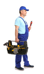 Mature plumber with pipe wrench and tool bag on white background