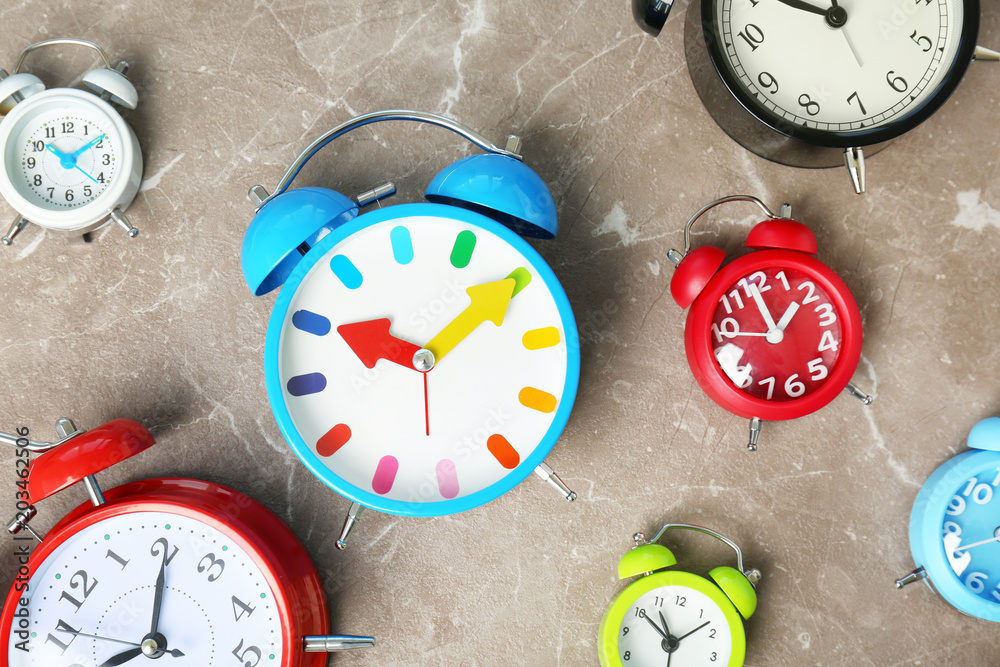 Poster many different alarm clocks on table. time change concept