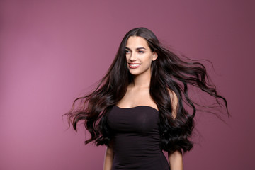 Naklejka premium Portrait of beautiful model with gorgeous curly hair on color background