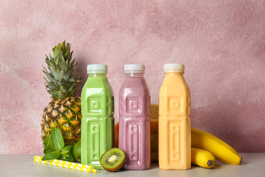 Bottles with healthy detox smoothies and ingredients on table