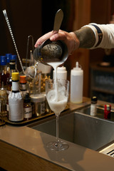 Fototapeta na wymiar Professional bartender making a cocktail at the bar counter, close-up