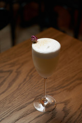 Glass with alcoholic cocktail drink on table, close-up