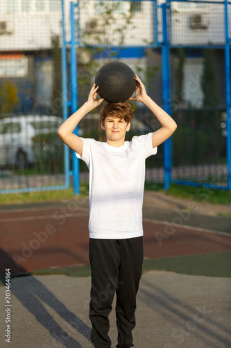 cute sporty teenage european boy playing basketball outdoorscute sporty teenage european boy playing basketball outdoors preparing for shooting active lifestyle