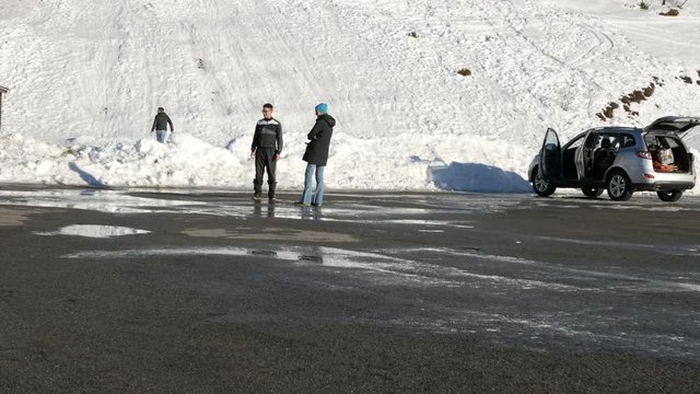 Bielmonte, Italy, January 21, 2018 Baby plays in the puddle with his family, snowy winter scenic, Alps, Italy
