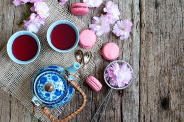 Tea concept, cups with tea and traditional teapot decorated with blooming spring tree branch 