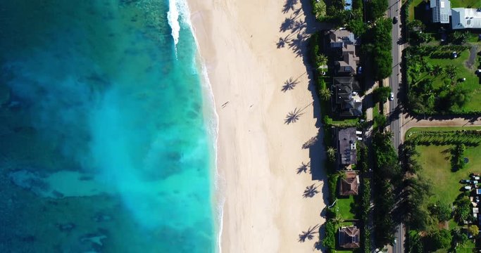 Aerial top down view of white sand beach and blue ocean waves in Hawaii
