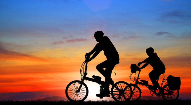 silhouette  Mountain bike and love couple in  the holiday on sunrise time